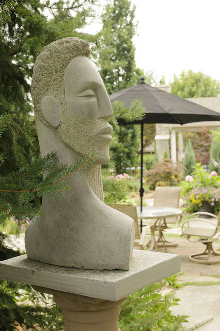 Garden art. Stone sculpture in its backyard setting. Daphne & Apollo. Limestone.