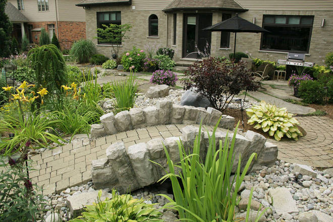 Hand-hewn stone bridge, stone landscape and paver pathway.