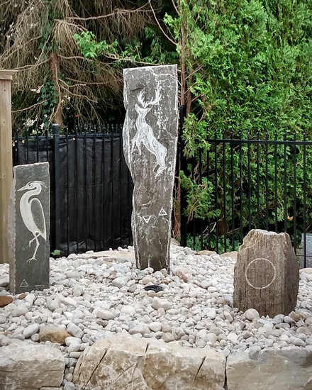 Totem installation featuring hand carved relief work in 3 granite pieces up to 72in high and 1200 lbs. Private Garden, London, Ontario.