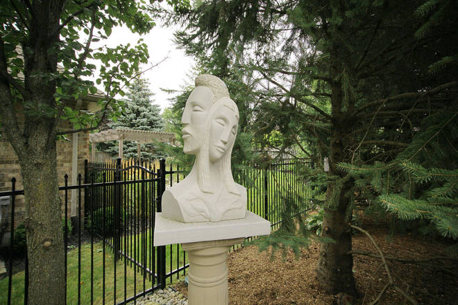 Garden art. Stone sculpture in its backyard setting. Daphne & Apollo. Limestone.